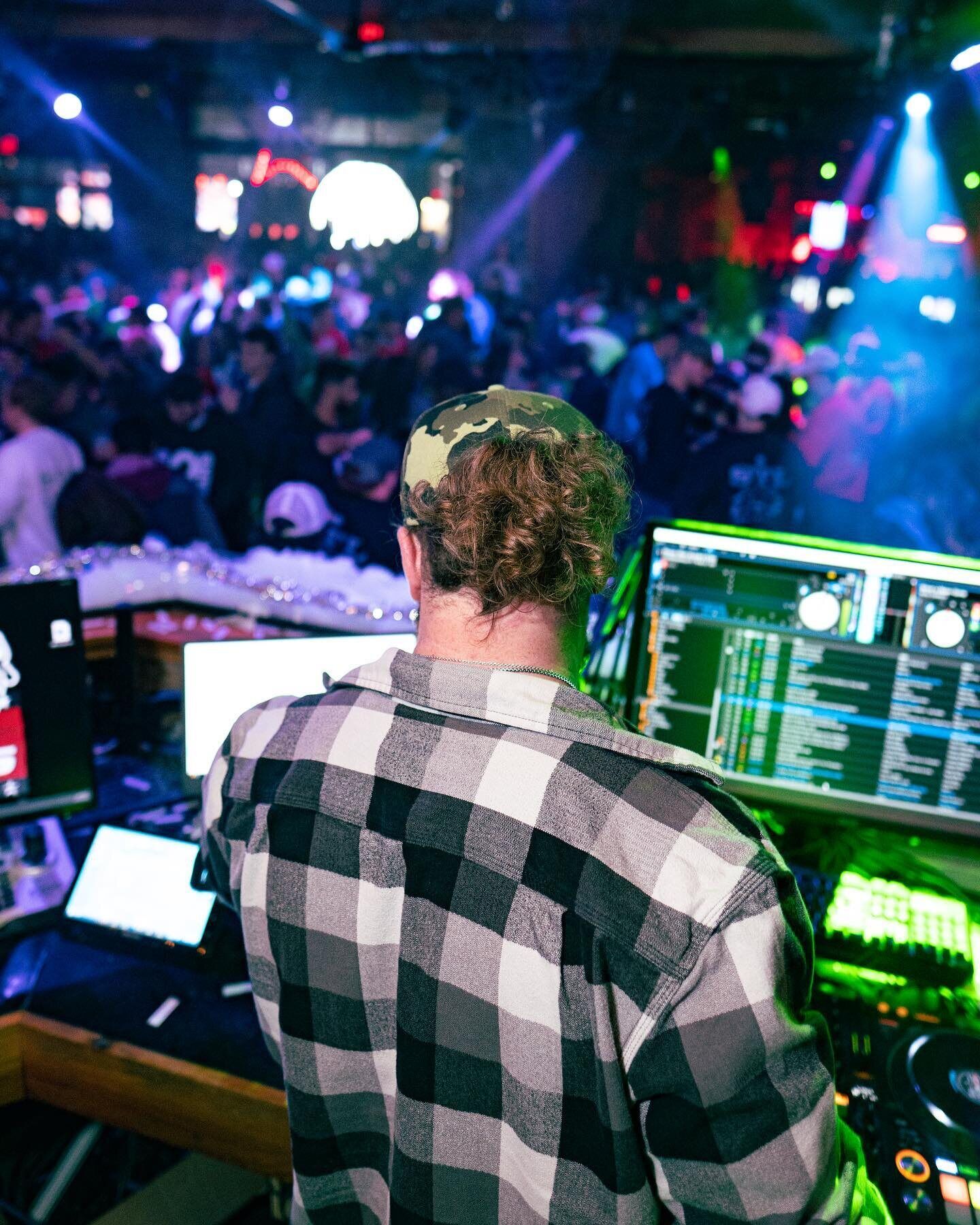 Dom mixing music behind the DJ booth